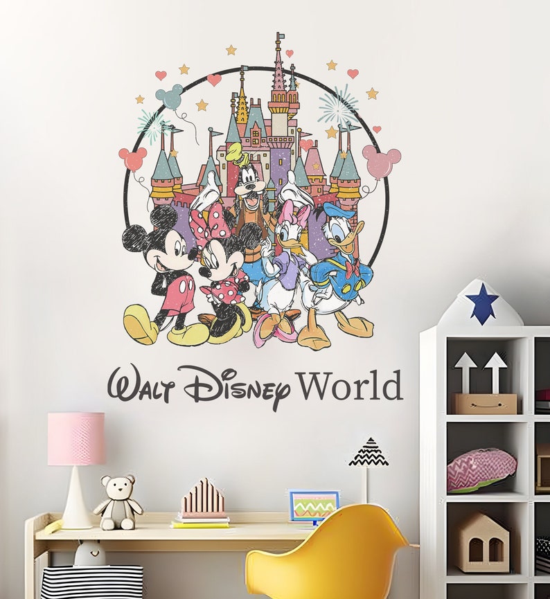 May include: A colorful wall decal featuring Mickey Mouse, Minnie Mouse, Donald Duck, Goofy, and Pluto standing in front of Cinderella's Castle. The decal is surrounded by a circle with stars and hearts. The text "Walt Disney World" is below the characters.