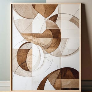 Op de afbeelding: Abstract geometrisch kunstwerk met een witte achtergrond en bruine houten accenten. Het kunstwerk is ingelijst in een licht houten lijst.