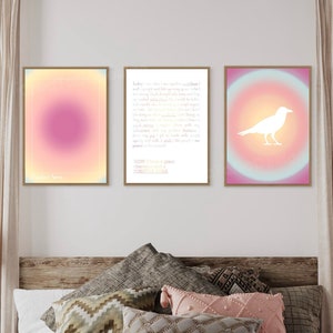 May include: Three framed wall art prints with a gradient background. The left print has a pink and yellow gradient. The middle print has a white text overlay on a pink and blue gradient. The right print has a white silhouette of a bird on a pink and blue gradient.