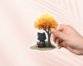 May include: A die-cut sticker featuring a black cartoon cat reading a book under a tree with orange and yellow leaves. The cat is sitting on green grass, and the sticker has a white border.