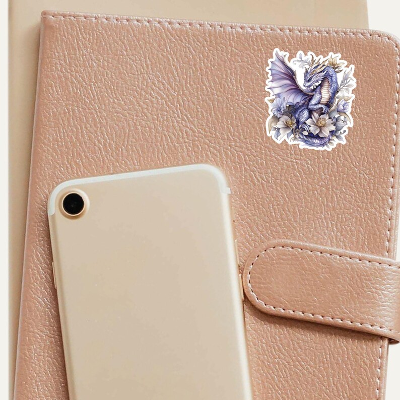 May include: A sticker featuring a purple dragon with wings spread, surrounded by white flowers. The dragon is perched on a branch with its head turned to the side.