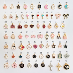 May include: A collection of 71 colorful enamel charms in various shapes, including flowers, hearts, keys, bows, stars, and crosses. Each charm has a gold-tone metal finish and is designed for jewelry making or crafting.