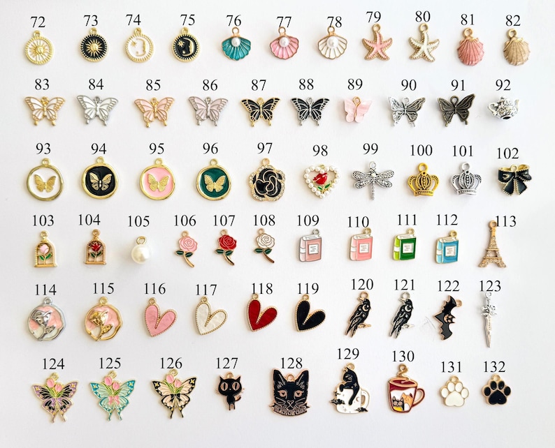 May include: A collection of small, decorative charms in various shapes and colors. The charms include butterflies, hearts, flowers, animals, and other designs. They are likely used for jewelry making or crafting.