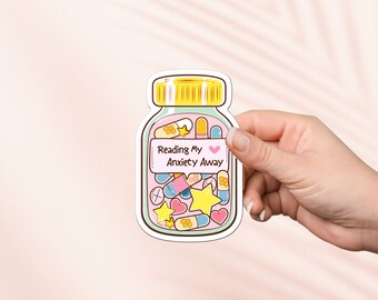 May include: A sticker of a pill bottle filled with colorful pills, stars, and hearts. The label on the bottle reads "Reading My Anxiety Away" with a pink heart.