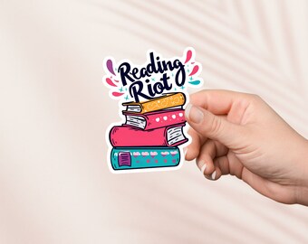 May include: A sticker with a stack of colorful books and the text "Reading Riot" in a black and white font.