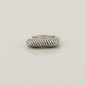 May include: A silver ring with a textured, ridged design. The ring's surface features a series of curved, parallel lines, creating a wave-like pattern. The ring is set against a plain, light-colored background.