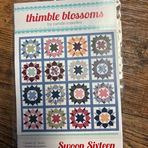 Könnte beinhalten: Ein Quilt-Anleitungsheft mit dem Titel Thimble Blossoms von Camille Roskelley mit dem Swoon Sixteen Design. Das Cover zeigt ein Raster aus sechzehn sternförmigen Quiltblöcken in verschiedenen floralen und geometrischen Mustern.