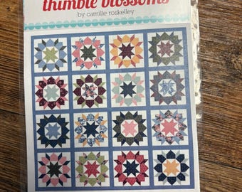 May include: A quilt pattern booklet titled Thimble Blossoms by Camille Roskelley featuring the Swoon Sixteen design. The cover displays a grid of sixteen star-shaped quilt blocks in various floral and geometric patterns with sixteen 16 inch blocks.