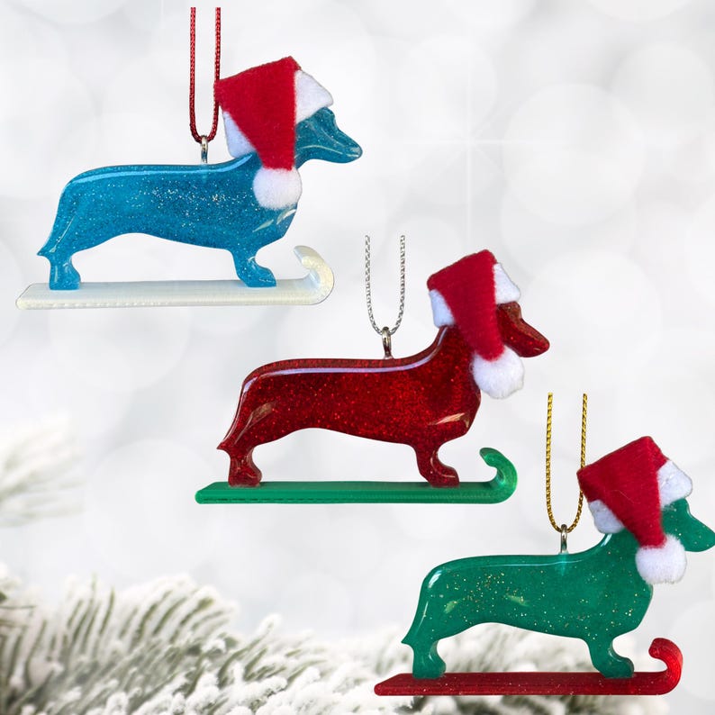 Handmade Dachshund Christmas Ornament made with high quality epoxy resin. These doxie wiener dog ornaments are available in Red, Green, or Blue. Includes a decorative tree ornament hanger.  Makes a great gift or stocking stuffer.