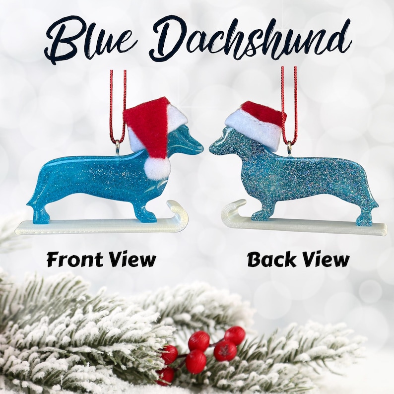 Handmade Dachshund Christmas Ornament made with high quality epoxy resin. The blue ornament comes with a red hanger and white sled with subtle silver glitter highlights on the front and dazzling glitter on the back.