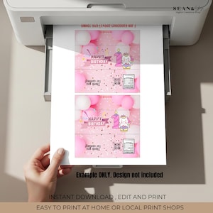 May include: Printed pink and white birthday-themed chocolate bar wrappers. The design includes the text "HAPPY BIRTHDAY", a number one candle, and a cartoon unicorn. The wrappers are printed on a white printer.
