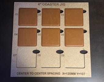 May include: A wooden jig for making 4-inch coasters. The jig has nine slots for coasters, numbered 1 through 9. The jig has a label that reads "4" COASTER JIG" and "CENTER TO CENTER SPACING X=120MM Y=107".