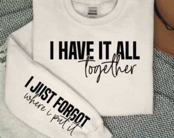 May include: White sweatshirt with black text that reads "I have it all together" on the front and "I just forgot where I put it" on the sleeve.