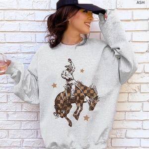 Vintage Western Crewneck Retro Cowboy Sweatshirt Checkered Pattern Design Bucking Bronco Graphic Rodeo Style Pullover Ranch Life Apparel Country Fashion Statement Comfortable Cotton Blend Western Lifestyle Clothing Casual Daily Wear