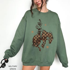 Bucking Bronco Sweatshirt Western Cowboy Crewneck Retro Checkered Design Rodeo Style Pullover Country Fashion Statement Ranch Wear Essential Cotton Polyester Blend Comfortable Western Apparel Casual Daily Outfit Vintage Western Look Unisex
