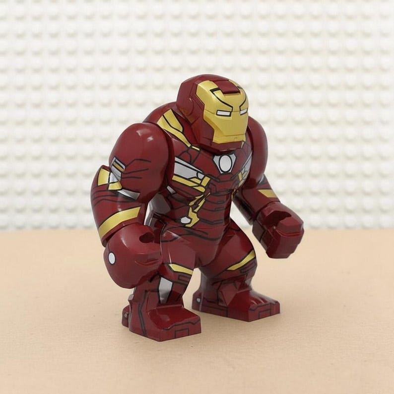 Pu&ograve; includere: Una action figure di Iron Man rossa e oro. La figura ha un elmetto dorato con un design a occhi rettangolari e un corpo rosso con dettagli dorati. La figura &egrave; in piedi.