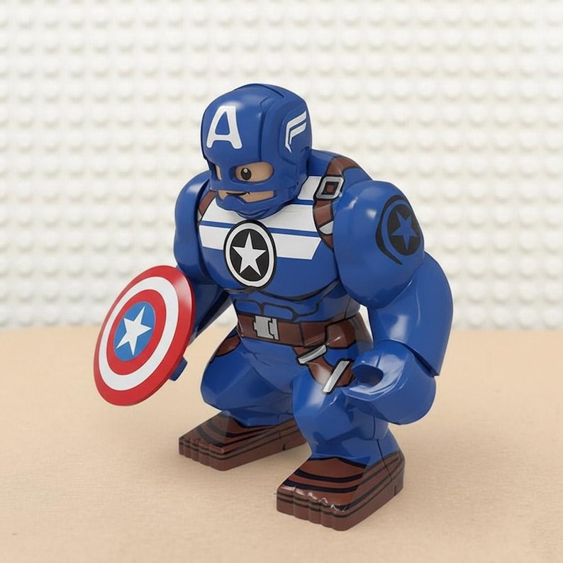 May include: A blue Captain America action figure with a shield. The figure has a blue helmet with a white "A" and white stripes. The shield is red, white, and blue with a white star. The figure is in a crouching position.