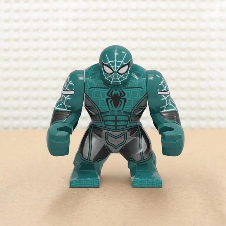 May include: A teal and gray action figure of a superhero with a spider-web design on the head and chest. The figure has a muscular build, with a black spider emblem on the chest and gray accents on the legs and arms.