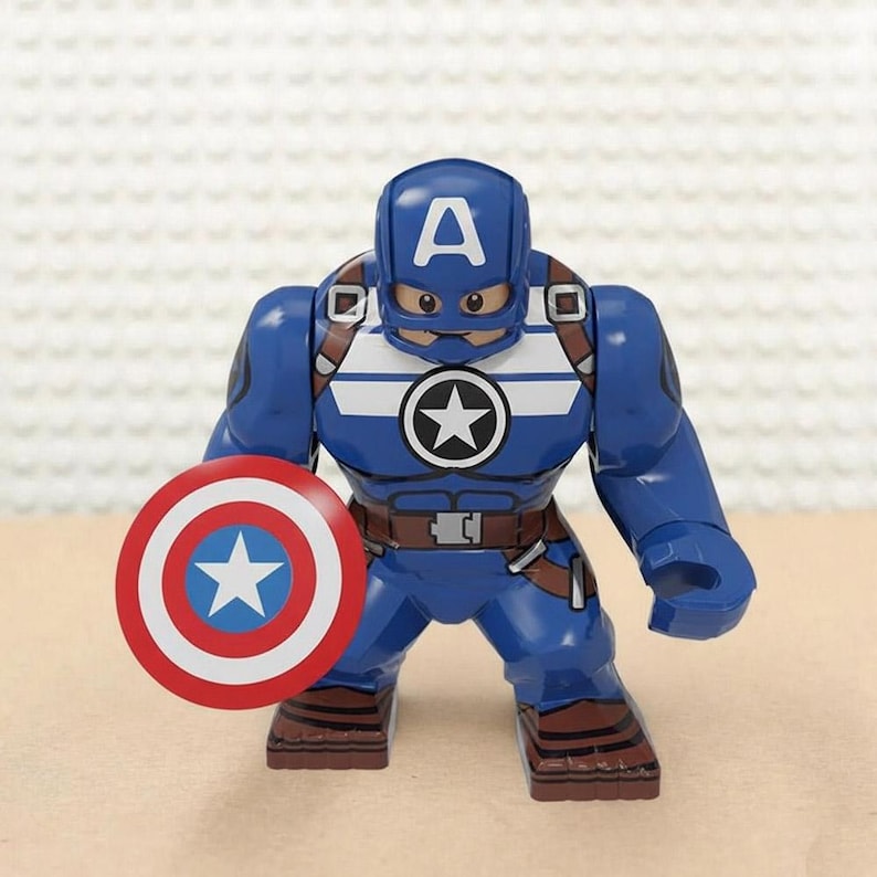 May include: A blue Captain America action figure with a white star on the chest and a matching shield. The figure has a blue helmet with a white "A" and brown straps. The shield is red, white, and blue.