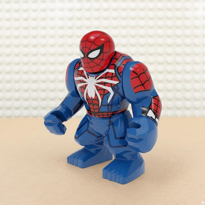May include: A blue and red Spider-Man action figure. The figure has a red head with a black spiderweb pattern and white eyes. The torso is blue with a white spider emblem. The figure is in a standing pose.