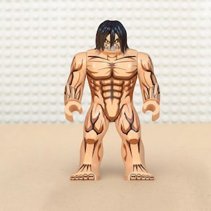 May include: A tan-colored toy figure with black hair and a fierce expression. The figure has detailed muscle definition and black markings. The toy is a building block figure, with a block-like design.