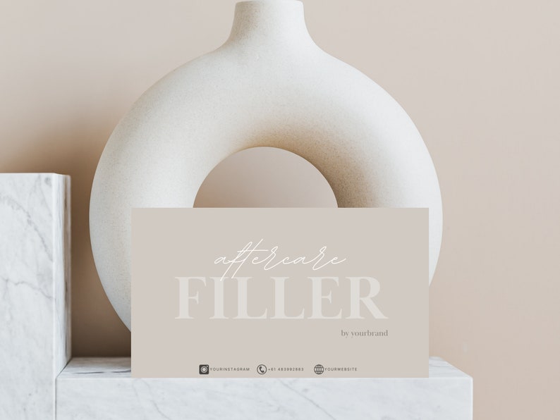 May include: A light brown card with the text "aftercare FILLER by yourbrand" in white. The card is sitting on a white marble surface with a white ceramic vase in the background.