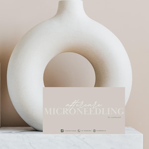 Puede incluir: Una tarjeta de color marr&oacute;n claro con el texto "aftercare MICRONEEDLING by yourbrand" en letra blanca. La tarjeta est&aacute; sobre una superficie de m&aacute;rmol blanco delante de un jarr&oacute;n de cer&aacute;mica blanco.