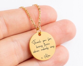 May include: Gold necklace with a round pendant that says "Thank you for being there when nobody was" with a signature "x Alex" at the bottom.
