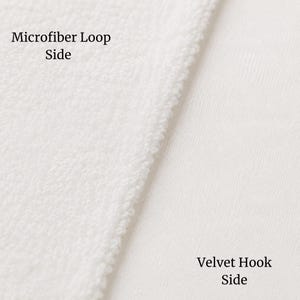 May include: A white fabric material showing two distinct textures side by side. The left section is labeled Microfiber Loop Side and features a textured, looped surface. The right section is labeled Velvet Hook Side and has a smooth finish.