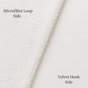 May include: A white fabric material showing two distinct textures side by side. The left section is labeled Microfiber Loop Side and features a textured, looped surface. The right section is labeled Velvet Hook Side and has a smooth finish.