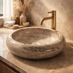 Side angle shot of a round marble wash basin placed on a wooden vanity, showcasing its depth and smooth curved edges. The natural stone design enhances bathroom aesthetics, making it suitable for contemporary and rustic interiors. A premium handcrafted piece for stylish home decor