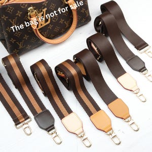 Pode incluir: Uma mala castanha com um padrão de monograma e detalhes em couro bege. Várias alças de mala listradas castanhas e bege são exibidas, juntamente com alças castanhas lisas. O texto "The bag is not for sale" é visível.