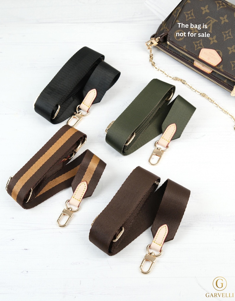 May include: Various replacement bag straps in black, olive green, and brown with gold-tone hardware. One strap has brown and tan stripes. The bag in the image is not for sale.