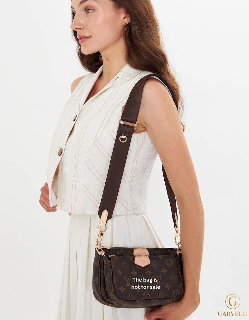 May include: Brown monogram crossbody bag with a detachable strap. The bag features a repeating pattern of the brand's logo and the text "The bag is not for sale". The bag has gold-colored hardware and a brown strap.