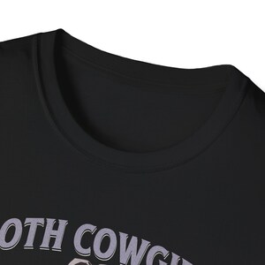 Pu&ograve; includere: Maglietta nera con il testo "Both Cowgirls" in bianco e viola.