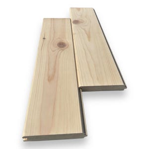 Può includere: Due pezzi di assi di legno chiaro non finito con un design a incastro maschio-femmina. Le assi sono disposte in uno schema sfalsato.