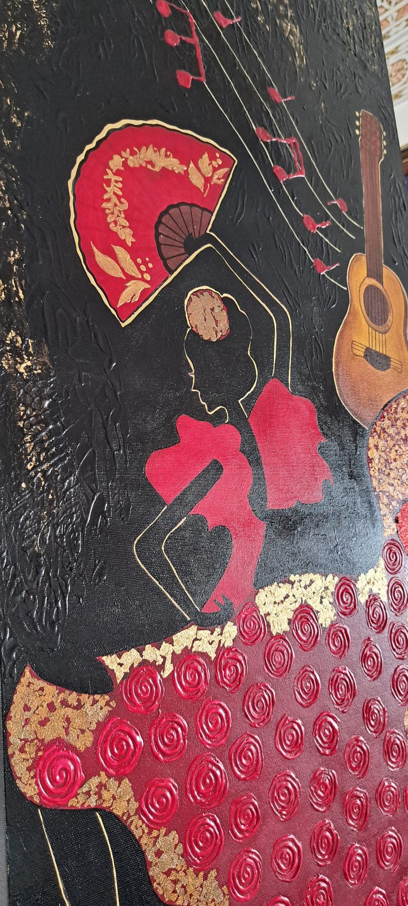 May include: A black canvas painting featuring a red and gold silhouette of a flamenco dancer. The dancer is holding a red fan and is wearing a red dress with gold accents. The background is black with gold musical notes.