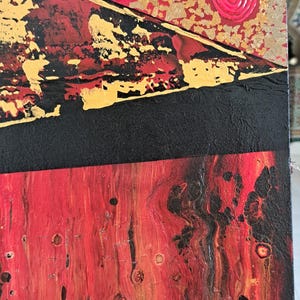 May include: Abstract painting on canvas with a red, black and gold colour scheme. The top portion of the painting features a pattern of pink swirls on a red background. The bottom portion of the painting features a red and black abstract design with gold accents. The painting is signed "Guimel Bourkadi" in the lower right corner.