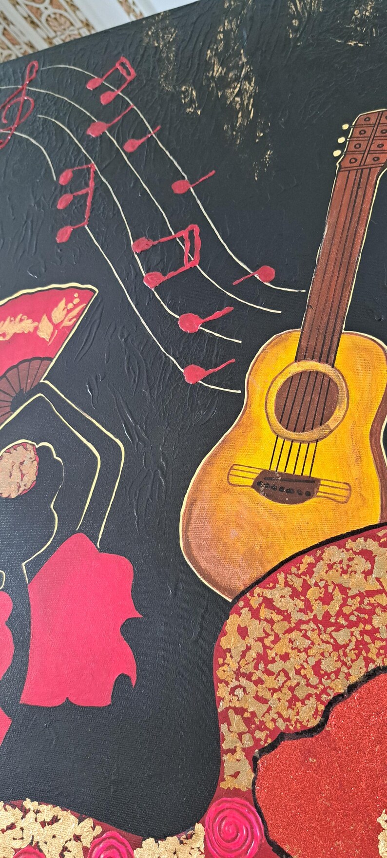 May include: A black canvas painting featuring a red and gold flamenco dancer, a yellow acoustic guitar, and red musical notes on a white background.
