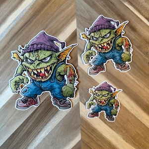 Goblin Troublemaker Vinyl Sticker | Waterproof Fantasy Creature Decal | Green Goblin with Beanie | Creature Collection