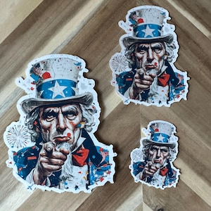 May include: Set of three stickers featuring an illustration of Uncle Sam pointing. The stickers vary in size and depict Uncle Sam in a patriotic hat, bow tie, and suit, with a stern expression.