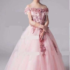 Op de afbeelding: Een lichtroze off-the-shoulder jurk met bloemenborduurwerk en een volle tule rok. De jurk heeft een bloemenlijfje en is geschikt voor speciale gelegenheden. De tekst "CARTAMODELLI DV" is linksboven zichtbaar.