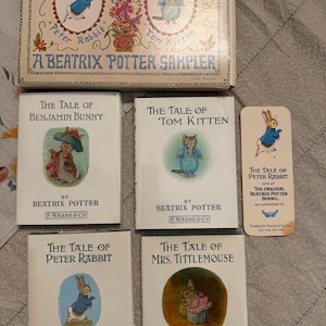 May include: A collection of Beatrix Potter books and a sampler box. The books include "The Tale of Benjamin Bunny," "The Tale of Tom Kitten," "The Tale of Peter Rabbit," and "The Tale of Mrs. Tittlemouse." The sampler box features illustrations of Peter Rabbit and Tom Kitten.