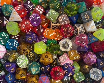 May include: A collection of colorful polyhedral dice in various shapes and sizes. The dice are made of translucent and opaque materials in shades of red, green, blue, purple, and yellow. Numbers are visible on the faces.