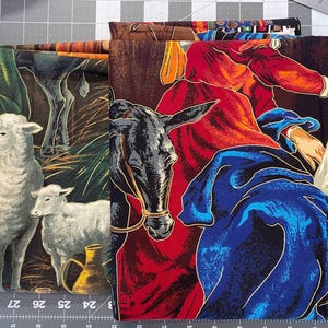 May include: Fabric panels with religious scenes. One shows sheep and a lamb, another a donkey and figures in red and blue robes. The fabrics have detailed illustrations with gold accents, ideal for quilting or craft projects.
