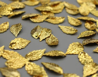 May include: A large quantity of gold-colored metal leaf charms. The leaves are detailed and have a slightly textured surface.