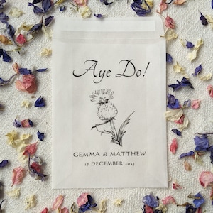 Opaque glassine packet for wedding favours. 'Aye do!' is written at the top with an image of a thistle in the centre followed by the couples names and the wedding date.