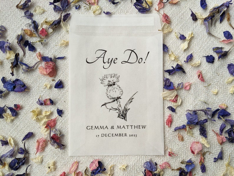 Opaque glassine packet for wedding favours. 'Aye do!' is written at the top with an image of a thistle in the centre followed by the couples names and the wedding date.