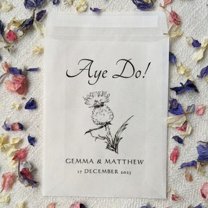 Opaque glassine packet for wedding favours. 'Aye do!' is written at the top with an image of a thistle in the centre followed by the couples names and the wedding date.