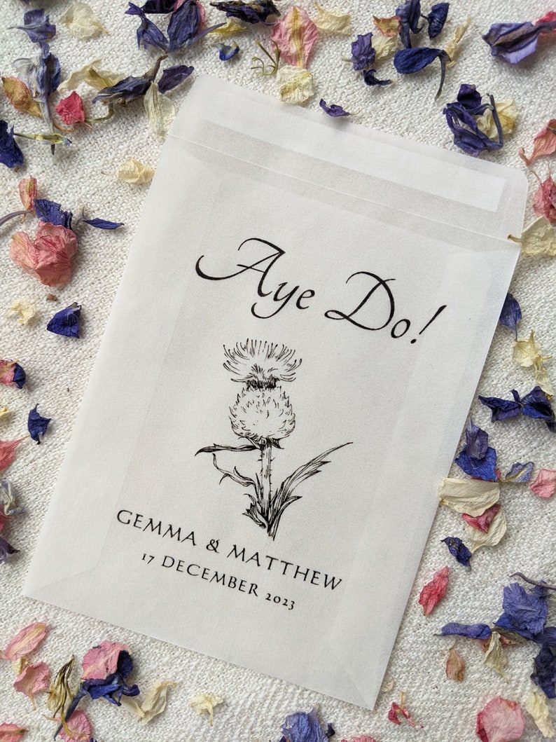 Opaque glassine packet for wedding favours. Aye do! is written at the top with an image of a thistle in the centre followed by the couples names and the wedding date.